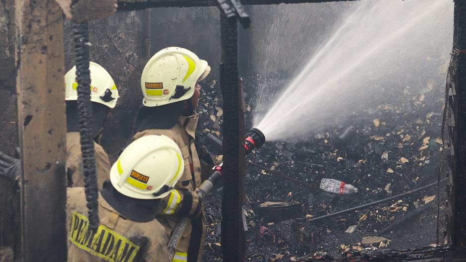 Firefighters spraying water on a fire